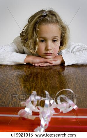 Stock Photography - Girl waiting to open gift. Fotosearch
