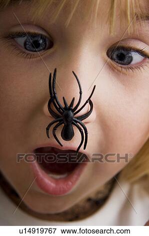 Stock Photo - Girl with spider on her nose. Fotosearch