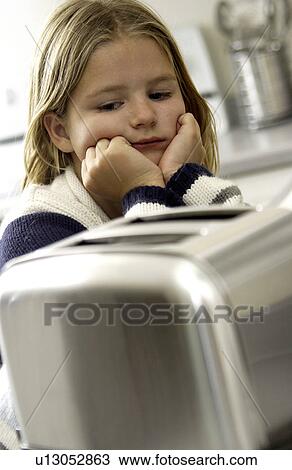 Stock Image - Young girl waiting on toaster. Fotosearch