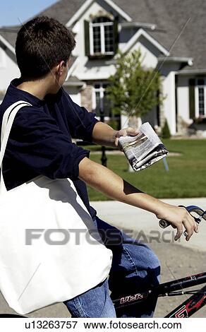 Boy delivering newspaper View Large Photo Image Stock Photo - Boy delivering newspaper. Fotosearch