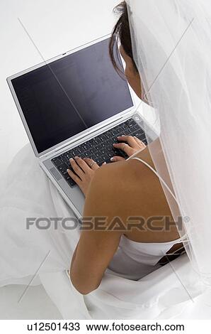 Stock Image - Bride using laptop. Fotosearch