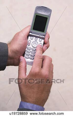 Stock Photo - Businessman dialing cell phone. Fotosearch