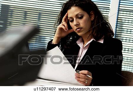 Stock Photo - Businesswoman working at desk. Fotosearch