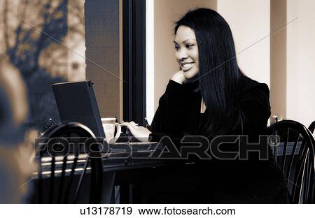 Businesswoman working on laptop in restaurant View Large Photo Image Stock Photo - Businesswoman working on laptop in restaurant. Fotosearch