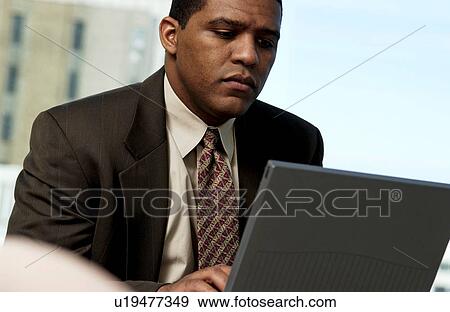Stock Photo - Man working on laptop. Fotosearch