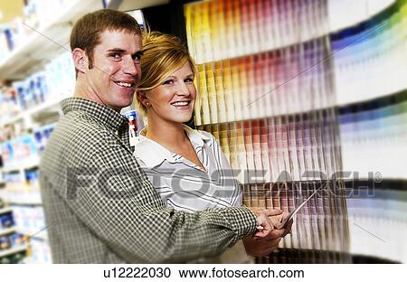 Stock Image - Couple looking at paint samples. Fotosearch
