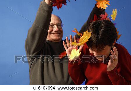 Picture - Older couple playing in the leaves. Fotosearch