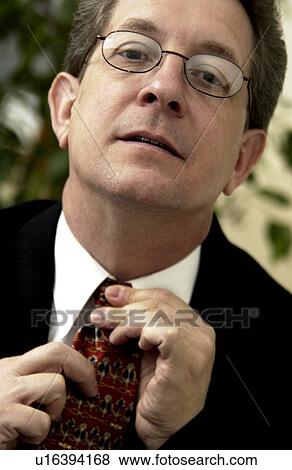 Businessman putting on tie View Large Photo Image Stock Photo - Businessman putting on tie. Fotosearch