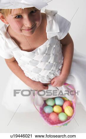 Stock Image - Girl holding Easter basket. Fotosearch