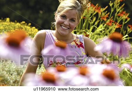 Stock Image - Woman in field of flowers. Fotosearch