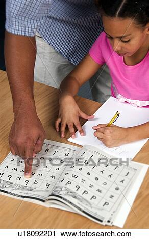 Stock Image - African American father helping daughter with homework. Fotosearch