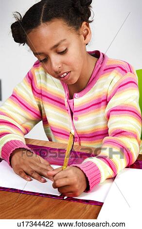 Stock Image - African American girl doing homework. Fotosearch
