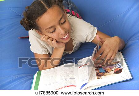 Stock Image - African American girl doing homework. Fotosearch