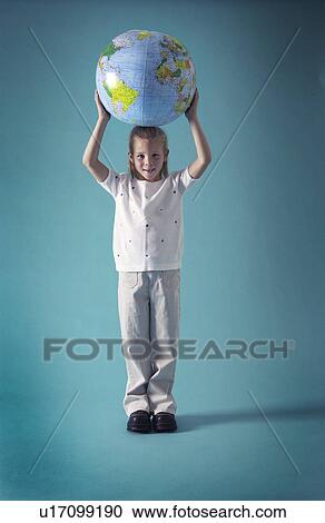 Stock Image - Girl holding globe over her head. Fotosearch