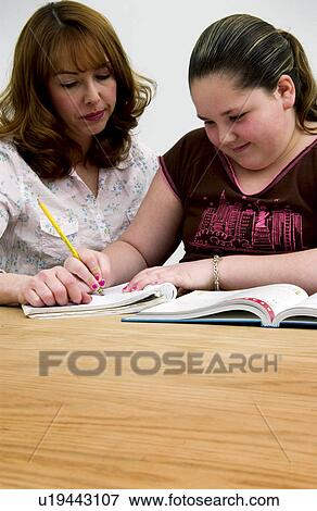 Mother or teacher helping girl with homework View Large Photo Image Stock Photo - Mother or teacher helping girl with homework. Fotosearch