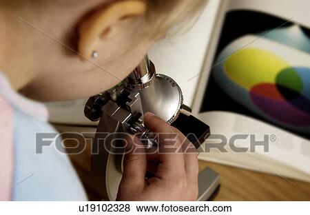 Stock Photo - Student looking through microscope. Fotosearch