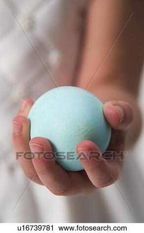 Stock Image - Child holding Easter egg. Fotosearch