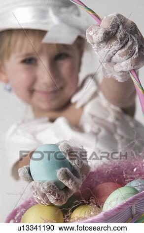 Girl picking eggs from basket View Large Photo Image Stock Image - Girl picking eggs from basket. Fotosearch