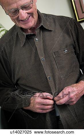 Senior man buttoning his shirt View Large Photo Image Stock Photography - Senior man buttoning his shirt. Fotosearch