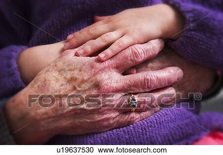 Stock Image - Senior woman holding childs hand. Fotosearch