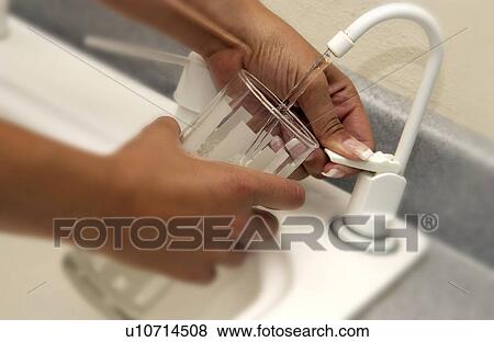 Stock Photo - Woman getting a glass of water. Fotosearch