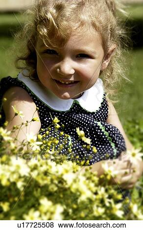 Stock Photo - Little girl holding a flower in her hands. Fotosearch