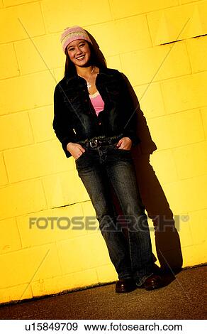 Teenager leaning against a yellow wall View Large Photo Image Stock Photo - Teenager leaning against a yellow wall. Fotosearch