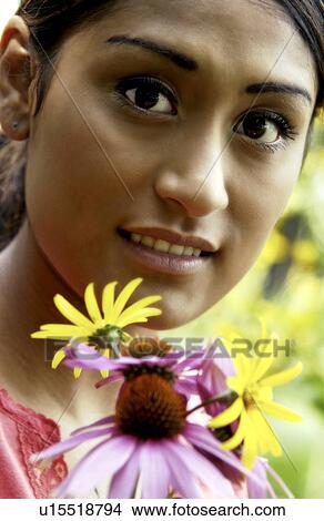 Picture - Woman holding flowers in garden. Fotosearch