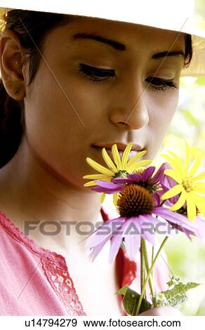 Stock Photo - Woman holding flowers in garden. Fotosearch