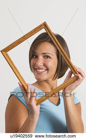 Stock Photo - Woman holding picture frame. Fotosearch