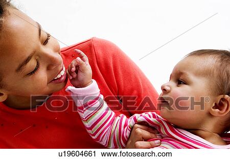 Stock Image - African American girl holding baby. Fotosearch