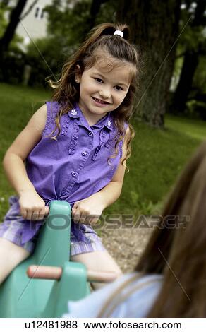 Stock Photo - Girl on teeter totter. Fotosearch
