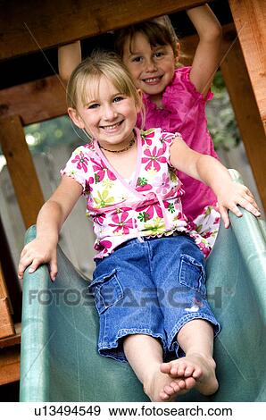 Girls going down slide View Large Photo Image Stock Photo - Girls going down slide. Fotosearch