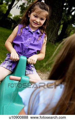 Stock Photo - Girls on teeter totter. Fotosearch