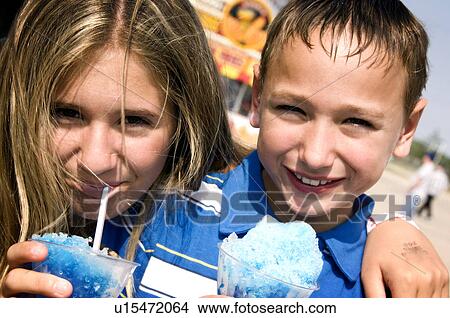 Picture - Kids eating carnival food. Fotosearch