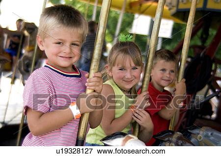 Stock Photo - Kids on merry go round. Fotosearch