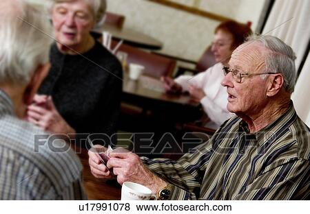Stock Photo - Seniors playing cards. Fotosearch