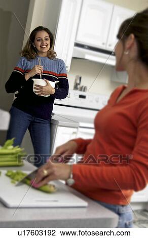 Two women cooking in the kitchen View Large Photo Image Stock Image - Two women cooking in the kitchen. Fotosearch