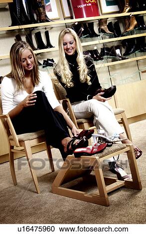 Stock Image - Two women in shoe store. Fotosearch