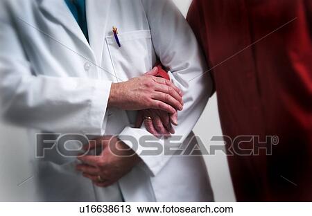 Stock Image - Medical staff helping senior to walk. Fotosearch