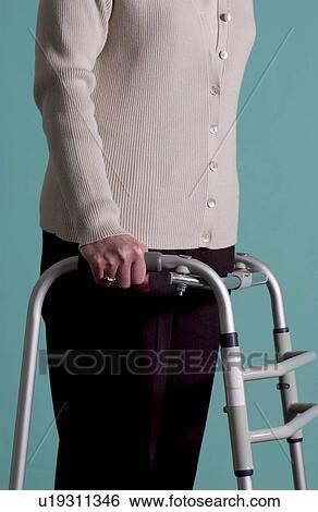 Stock Photograph - Senior woman walking with walker. Fotosearch