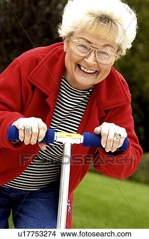 Picture - Woman riding a scooter. Fotosearch