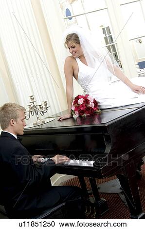 Stock Image - Bride and groom at piano. Fotosearch
