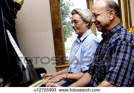 Stock Image - Couple playing piano. Fotosearch