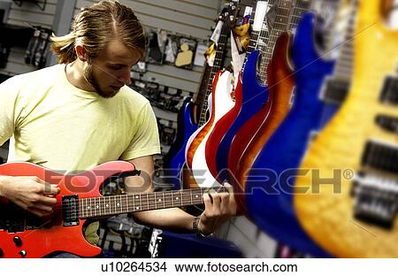 Man at guitar store View Large Photo Image Picture - Man at guitar store. Fotosearch