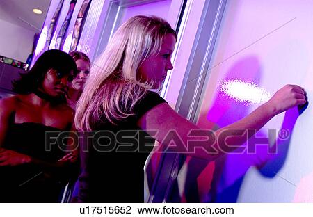 Stock Image - Girls waiting in line for restroom. Fotosearch