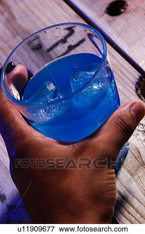Stock Photo - Person holding alcoholic drink. Fotosearch