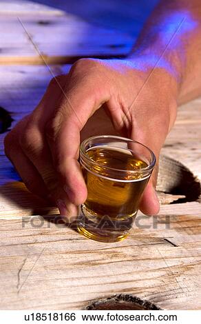 Stock Photograph - Person holding shot glass. Fotosearch