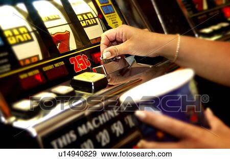 Stock Photo - Woman playing slot machine. Fotosearch