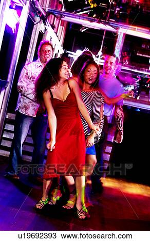 Stock Image - Young adults at a nightclub dancing. Fotosearch